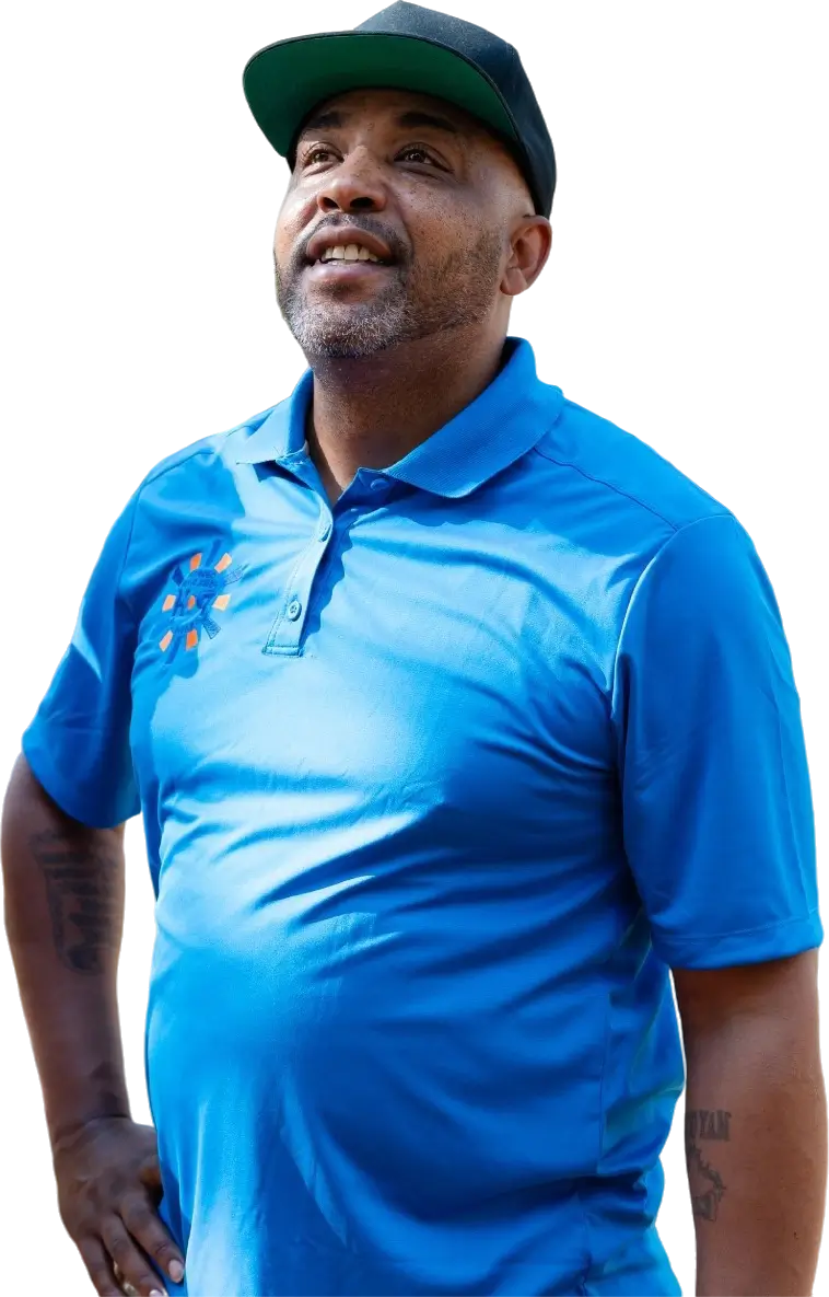A male professional in a blue polo shirt posing against a neutral background.